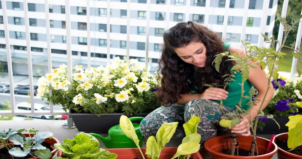 Mulher meditando em horta urbana, conectando sustentabilidade e qualidade de vida em um ambiente verde.