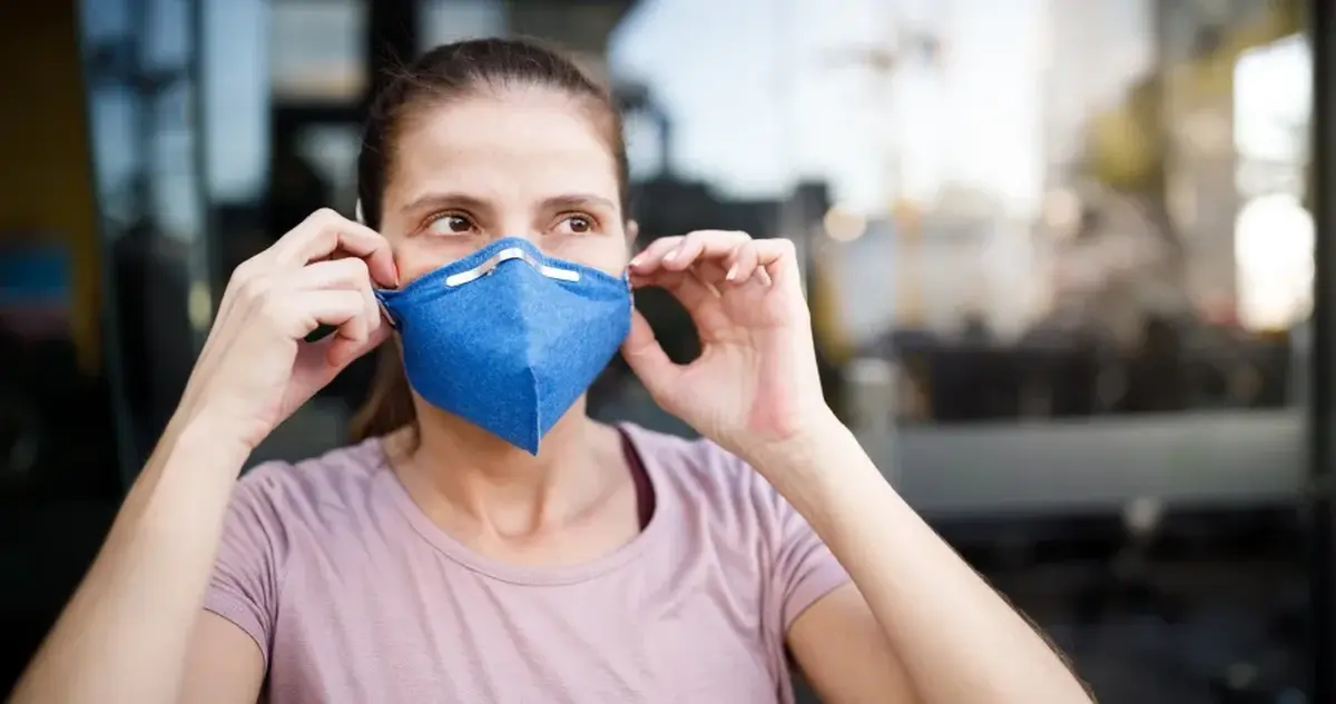 pessoa com máscara respiratória — impacto da poluição na saúde